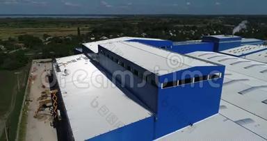 这座明亮的建筑是一座来自空中的现代化工厂，一座白色蓝色的大型工厂建筑，一座来自现代工厂的现代化工厂。